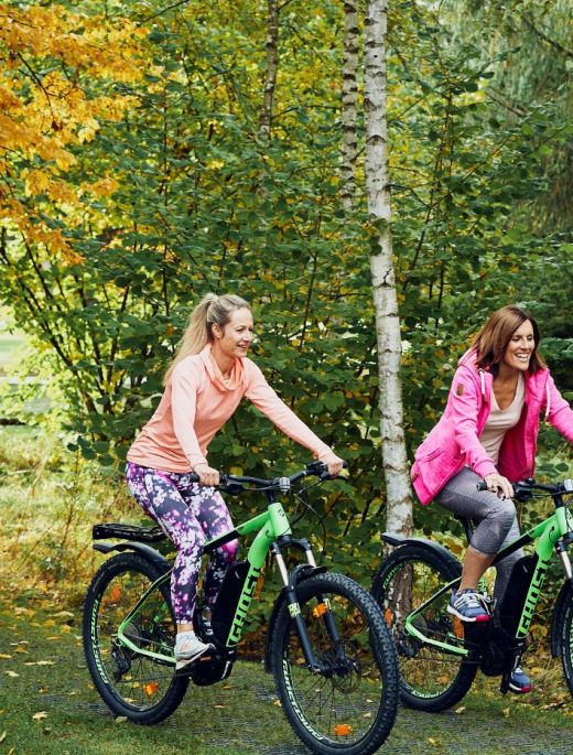 Zwei Frauen auf dem E-Bike im Wald im 5 Sterne Hotel im Schwarzwald