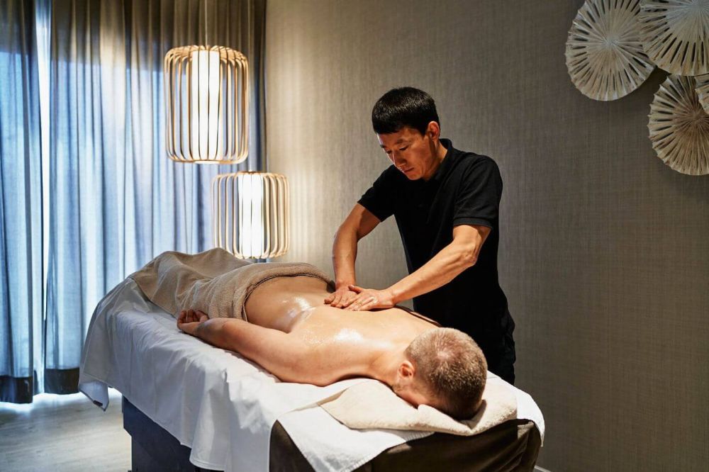 Mann bei der Herrenmassage im eleganten Wellnessbereich