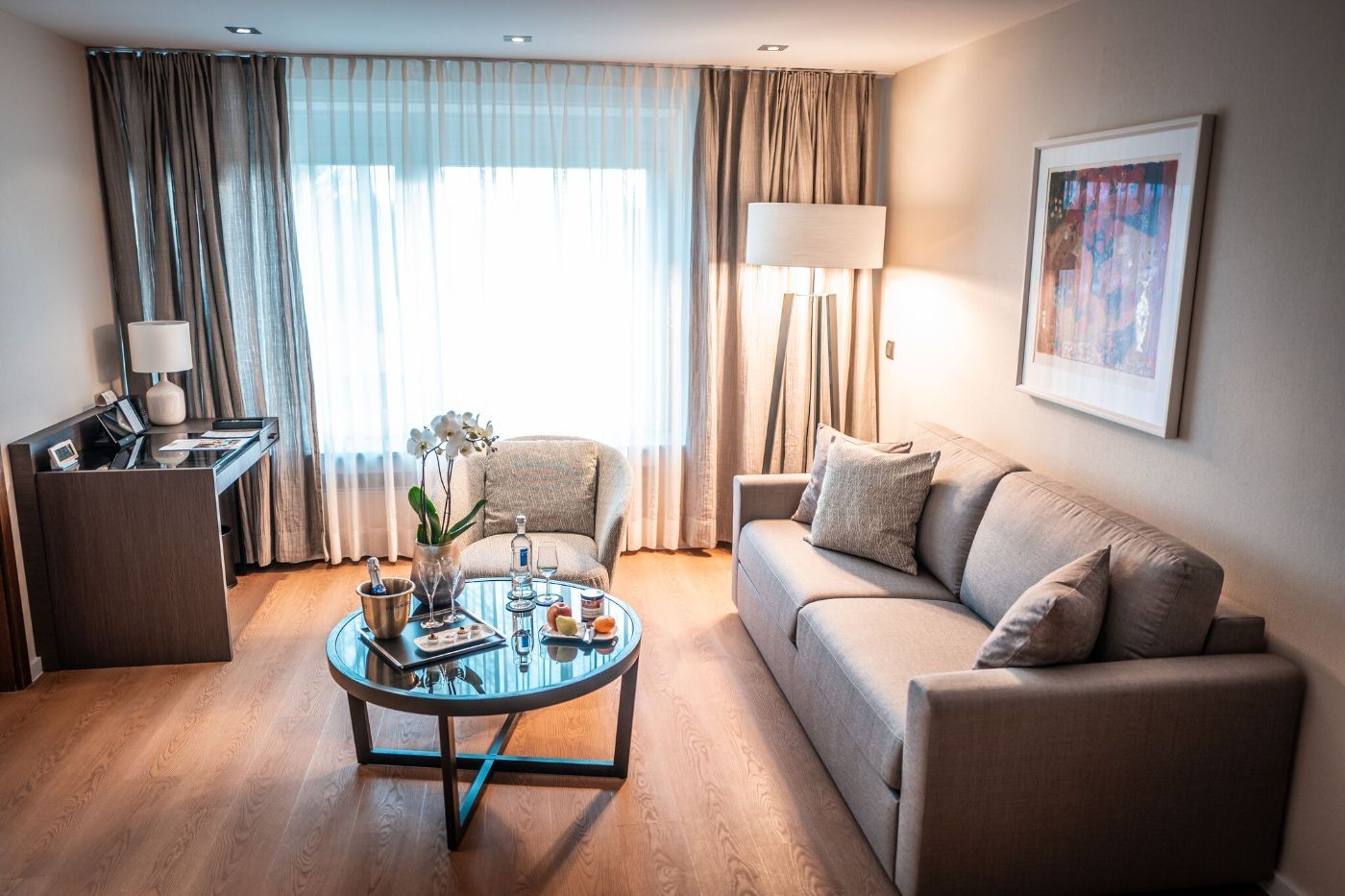 Wohnbereich mit grauer Couch und einem mit Orchideen dekoriertem Beistelltisch