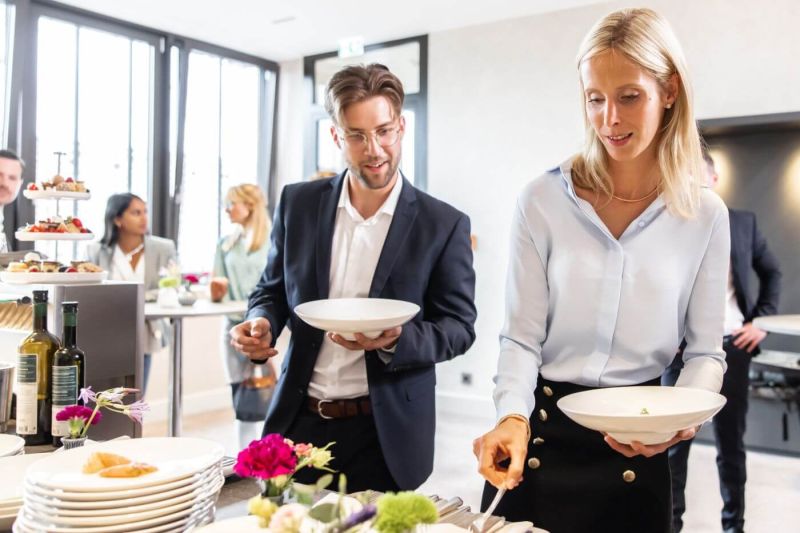 Zwei Tagungsbesucher bedienen sich am Buffet im Tagungshotel im Schwarzwald