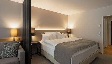 Ein großzügiges Doppelbett in einem modern eingerichteten Hotelzimmer