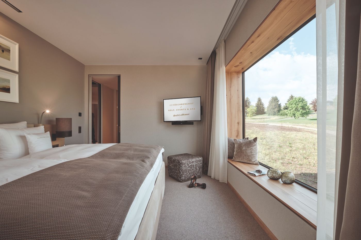 In hellen Farbtönen gestaltetes Schlafzimmer mit großem Fenster