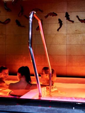 Drei Frauen in einem atmosphärisch beleuchteten Onsenbecken im Asia Spa