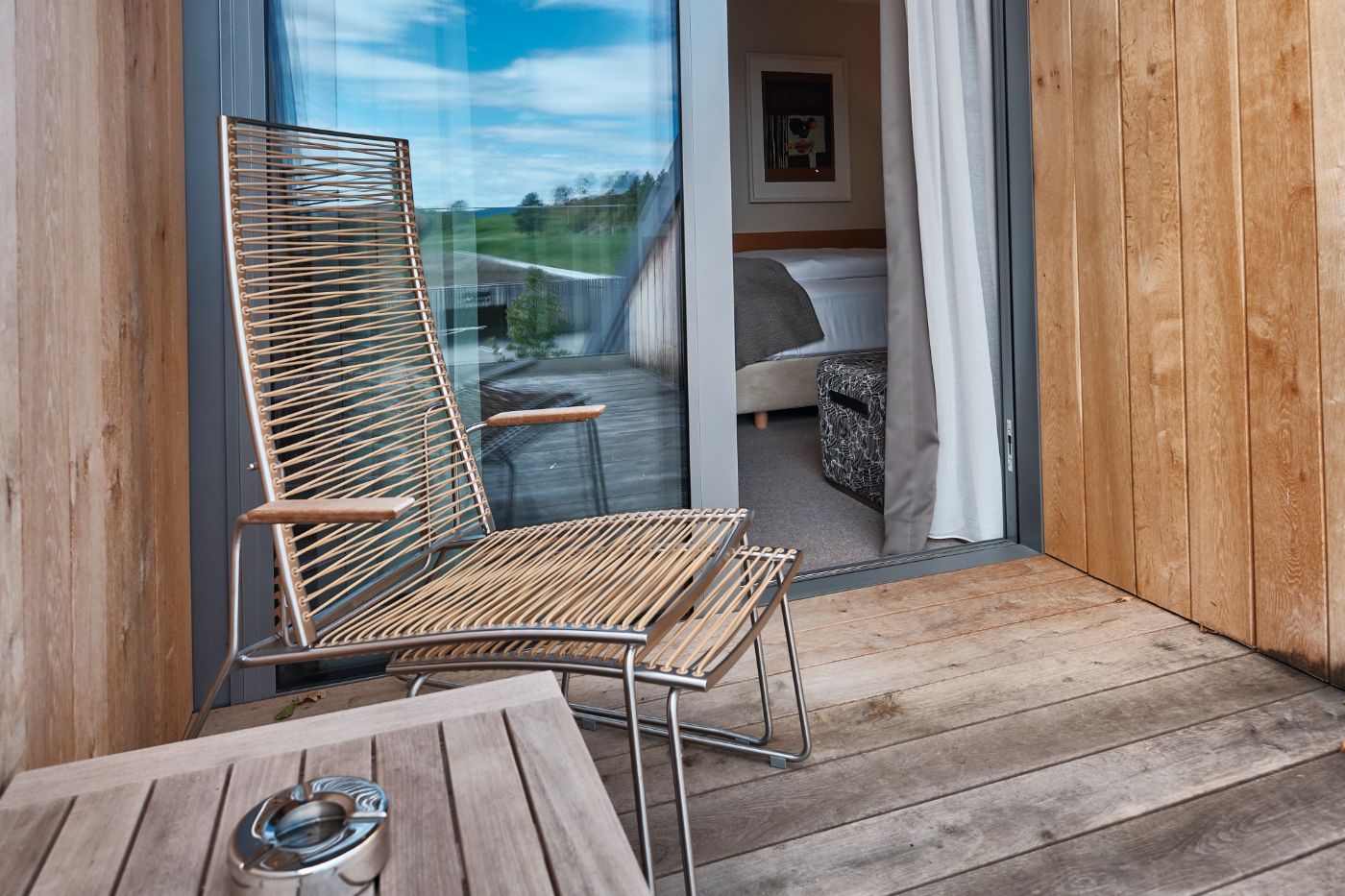 Rattanstuhl mit Fußablage auf dem Balkon