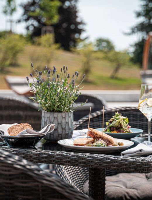 Tisch im Außenbereich des Spa Bistro mit einem Lavendelstrauch, Sandwich und einem Salat