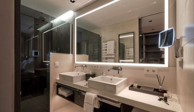 Beleuchteter Spiegel über zwei Waschbecken im Badezimmer im Schwarzwald