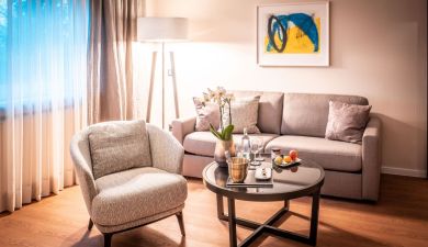 living area with armchair, couch and an abstract painting