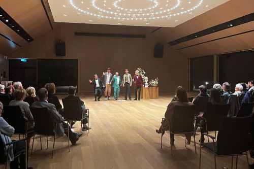 Five people in the center of the packed concert hall