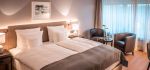 Doppelbett neben zwei runden Sesseln im Komfort Zimmer