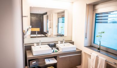 view into the bathroom of the suite dependance with a bathtub and two sinks