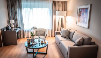 living space with a grey couch and a coffe table decorated with orchids