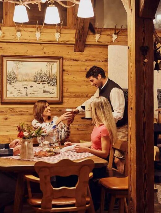 waiter serves drinks in the traditional Öventhütte