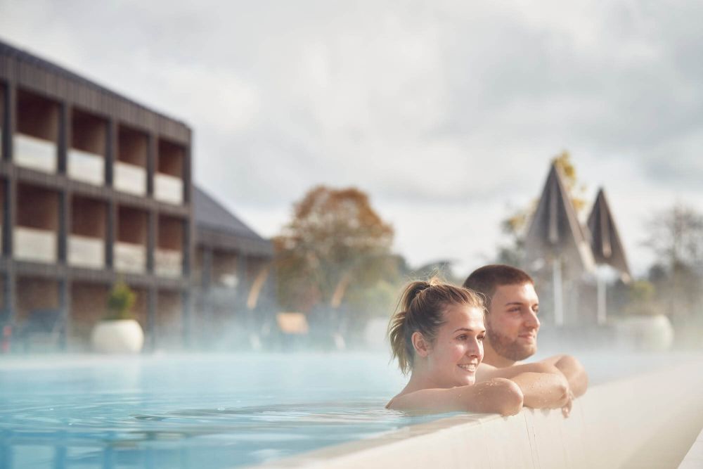 Paar hält sich am Beckenrand des Infinity-Pools