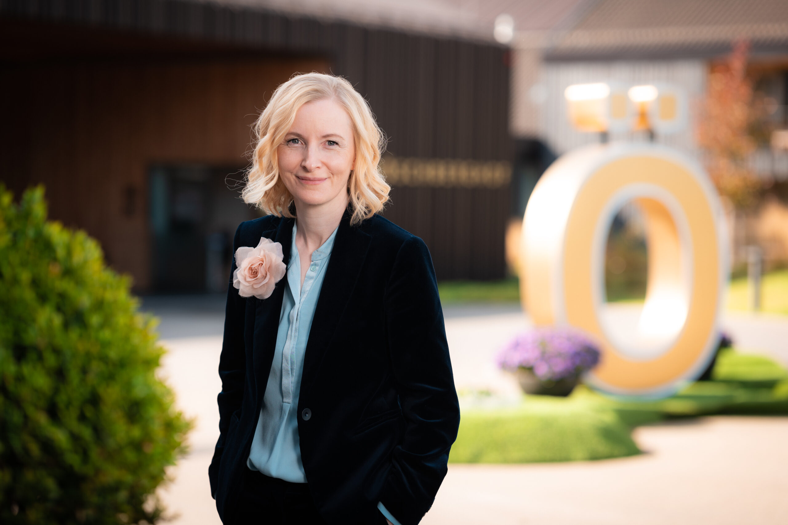 Ärztin Anne Fleck mit einer Ansteckblume auf dem Gelände des Öschberghofs vor dem goldenen Ö