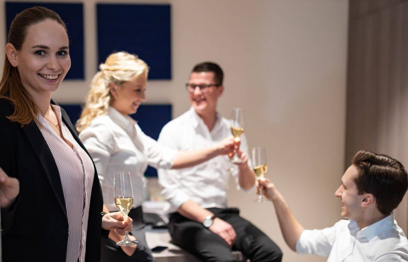 Hotel-Mitarbeiter beim gemeinsamen Anstoßen mit einem Glas Sekt