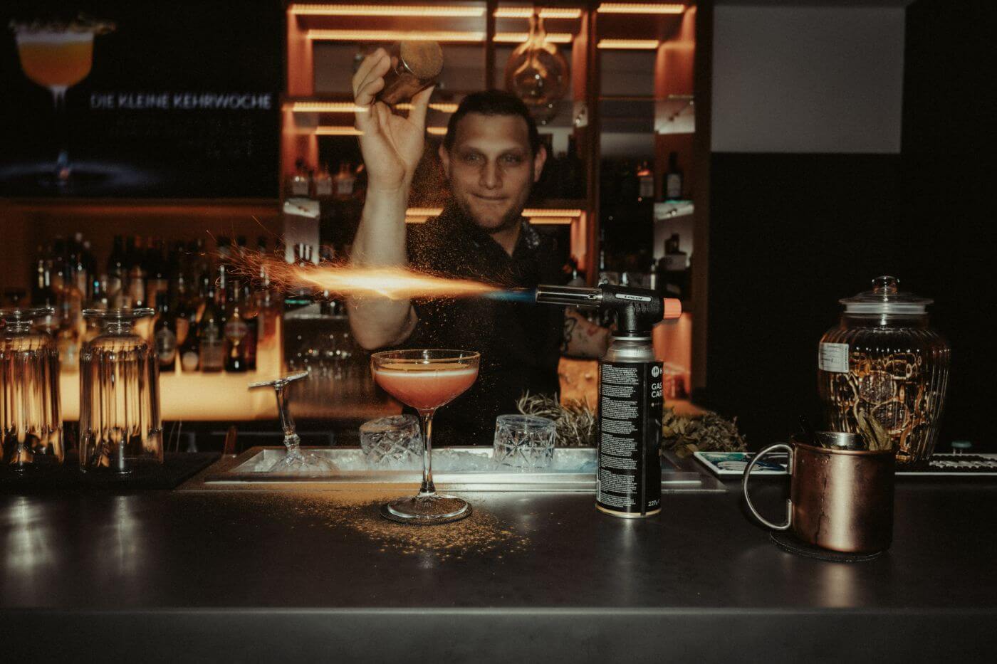 Ein Barkeeper verziert einen Cocktail